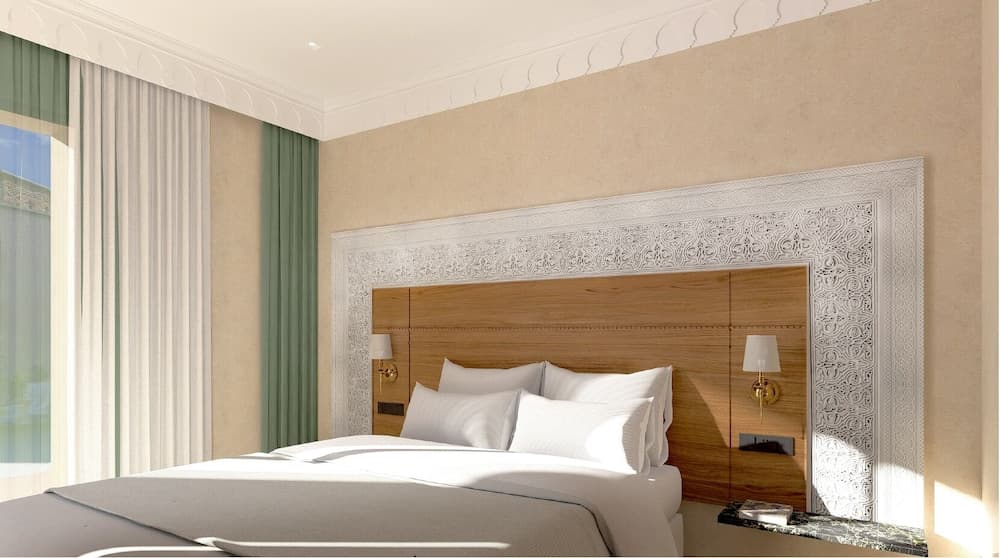 A serene hotel bedroom features a cozy bed adorned with white linens, framed by an ornate headboard and soft green curtains, ideal for travelers seeking relaxation and comfort.