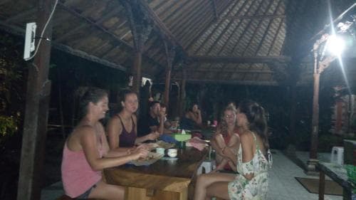 A cozy evening gathering under a rustic wooden pavilion with friends enjoying drinks and conversation, ideal for travelers seeking a relaxed social experience in an intimate outdoor setting.
