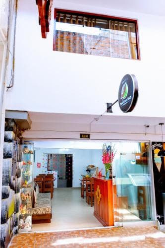 A cozy indoor café with vibrant decor, wooden furnishings, and a welcoming entrance exudes a relaxed atmosphere, perfect for travelers seeking a charming spot to unwind and enjoy local cuisine.