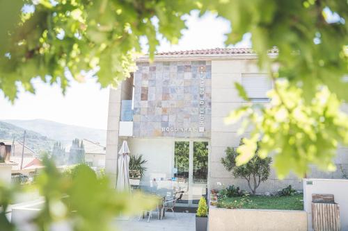 A serene outdoor seating area framed by lush greenery invites travelers to relax at a charming hotel nestled in a picturesque mountainous region, ideal for leisurely getaways.