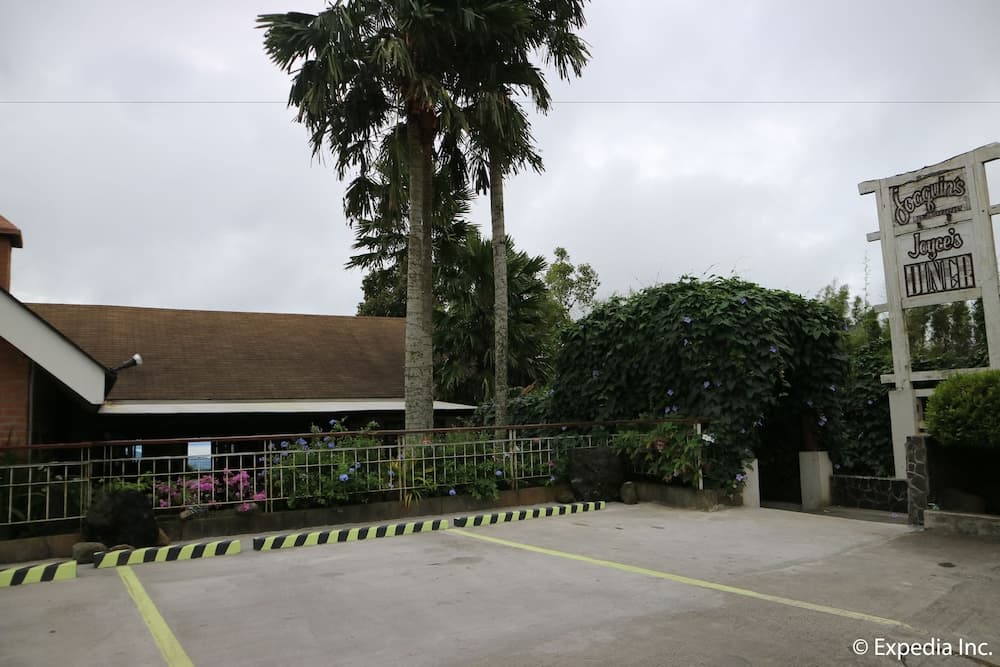 A serene tropical roadside diner entrance features lush palm trees, vibrant flowers, and a welcoming sign, ideal for travelers seeking a relaxing meal stop in a picturesque setting.
