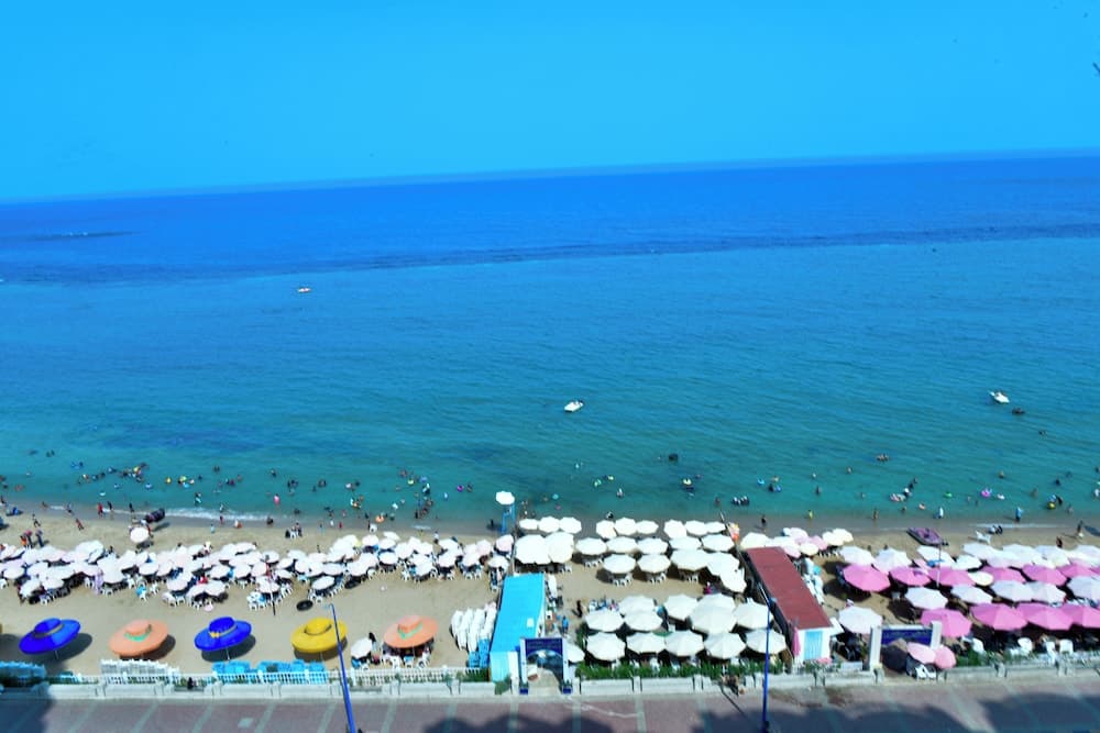 A vibrant beach scene with colorful umbrellas and clear turquoise waters under a bright blue sky, ideal for summer vacationers seeking relaxation and sunbathing spots.