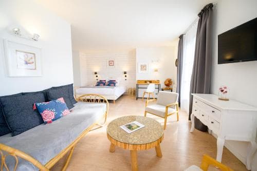 A cozy hotel room features a stylish sofa, a neatly made bed, and modern furnishings, creating a welcoming atmosphere ideal for travelers seeking comfort and relaxation.