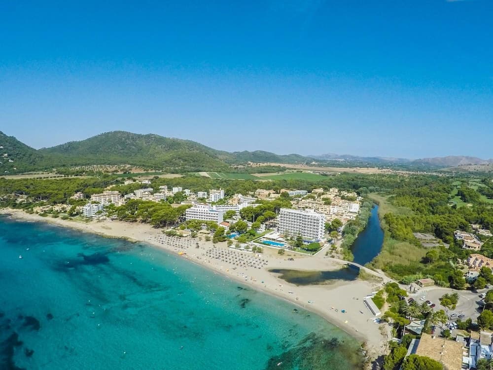 A serene coastal town nestled between lush green hills and turquoise waters offers an idyllic retreat, perfect for beach lovers seeking relaxation and scenic beauty.
