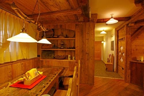 A cozy wooden cabin interior with warm lighting, rustic furniture, and inviting decor creates a serene retreat ideal for travelers seeking relaxation in a mountain lodge setting.