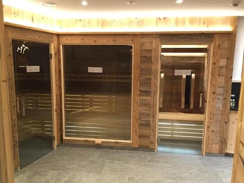 A cozy sauna area with wooden interiors and glass doors offers a relaxing retreat, ideal for wellness travelers seeking rejuvenation.