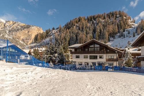 A serene winter scene showcases a cozy chalet nestled among snow-covered mountains, surrounded by evergreen trees and ski lifts, ideal for adventure seekers planning a ski vacation.