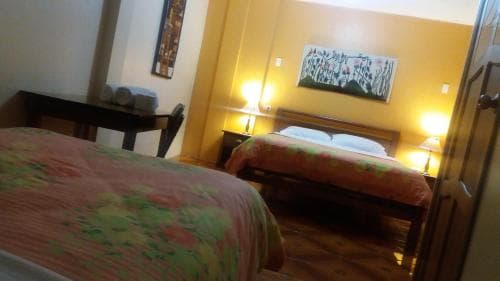 A cozy hotel room with warm lighting, colorful bedding, and wall art creates an inviting atmosphere ideal for travelers seeking comfort and relaxation.