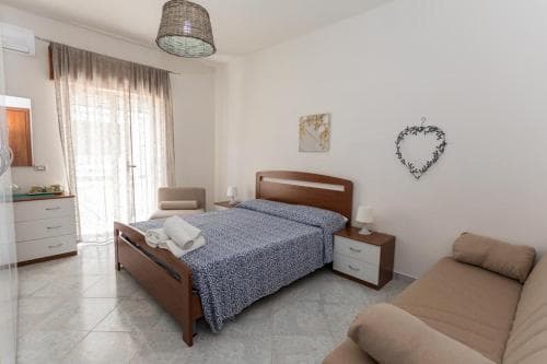 A cozy bedroom with tiled floors, wooden furniture, and soft lighting creates a serene atmosphere, ideal for travelers seeking relaxation in a comfortable vacation rental.