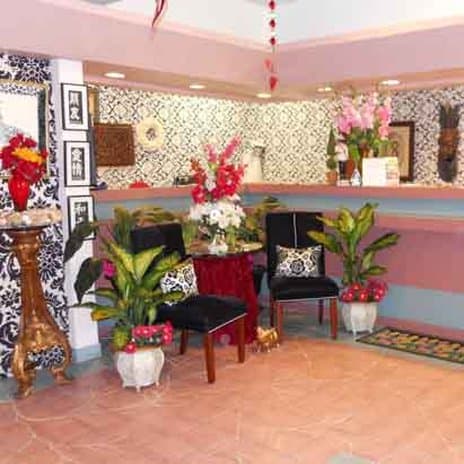 A vibrant hotel lobby adorned with floral arrangements, patterned walls, and cozy seating exudes a welcoming atmosphere, ideal for travelers seeking a comfortable and stylish check-in experience.
