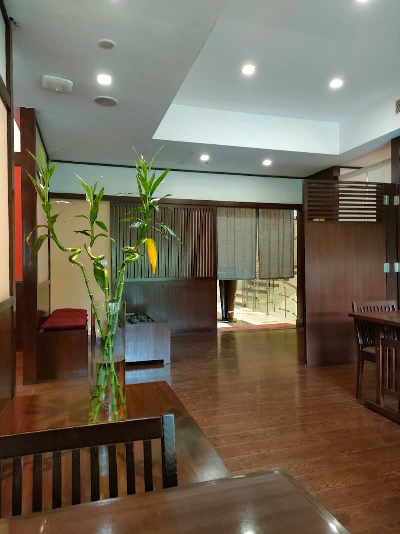 A serene hotel lobby in Gurugram, India, features polished wooden floors, bamboo plants, and modern furnishings, creating a welcoming atmosphere ideal for travelers seeking comfort and relaxation.
