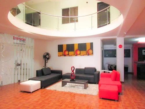 A vibrant hotel lobby features modern furniture, colorful decor, and a mezzanine level, creating an inviting atmosphere ideal for travelers seeking comfort and style during their stay.