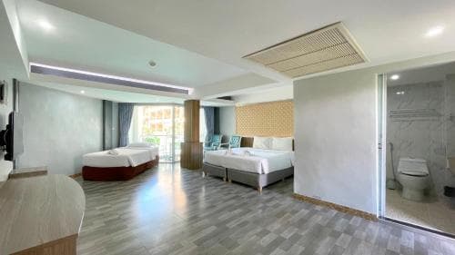 A modern hotel room with two cozy beds, a spacious bathroom, and a balcony view, exudes comfort and relaxation, ideal for travelers seeking a serene stay.