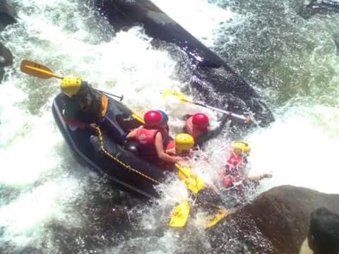 Adventurers in vibrant helmets navigate turbulent whitewater rapids on an inflatable raft, capturing the thrill of river rafting for outdoor enthusiasts seeking excitement.