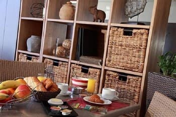 A cozy breakfast nook with a rustic wooden shelf displaying pottery and decor, set against a warm and inviting ambiance, perfect for travelers seeking a charming morning retreat.