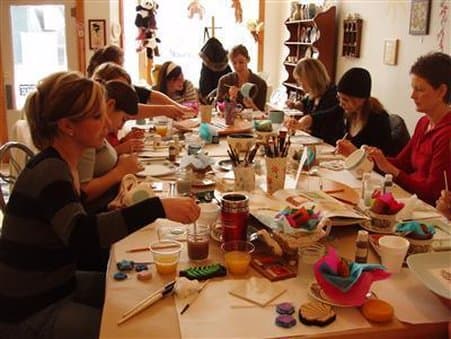 A cozy craft workshop filled with focused participants surrounded by colorful materials and tools, ideal for travelers seeking creative retreats or team-building activities.