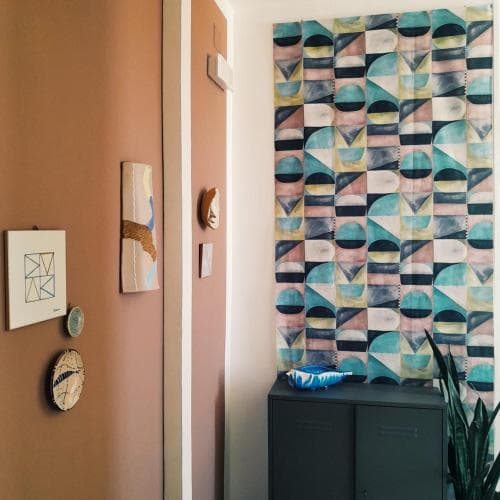A cozy indoor hallway adorned with vibrant geometric wall art and decorative plates exudes a creative and artistic vibe, perfect for travelers seeking unique home decor inspiration.