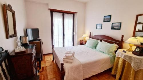 A cozy hotel room with warm wooden furnishings, a neatly made bed, and soft lighting creates an inviting atmosphere perfect for travelers seeking comfort and relaxation.
