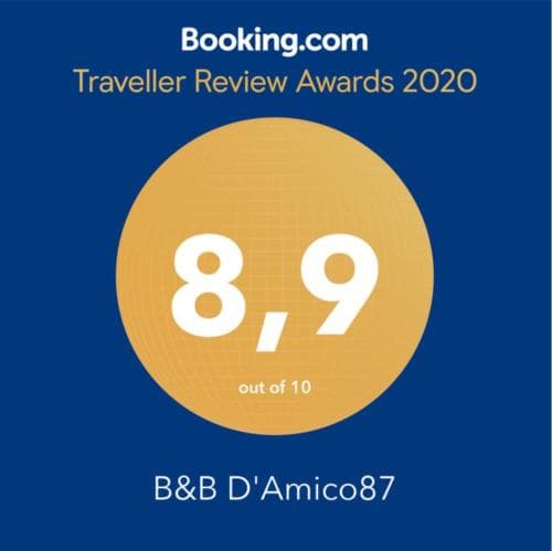 A vibrant blue backdrop highlights an 8.9 rating badge from Booking.com's Traveller Review Awards 2020, showcasing the accolade for B&B D'Amico87, ideal for travelers seeking top-rated accommodations.