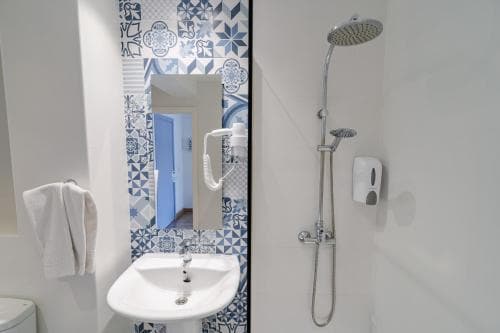 A cozy bathroom with blue patterned tiles and modern fixtures offers a serene space for travelers seeking comfort and cleanliness during their stay.