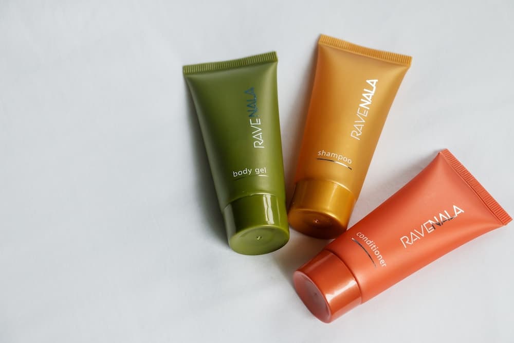 A minimalist display of colorful Ravenala body care products on a white surface evokes a clean, modern aesthetic ideal for travel and personal care enthusiasts seeking compact essentials.