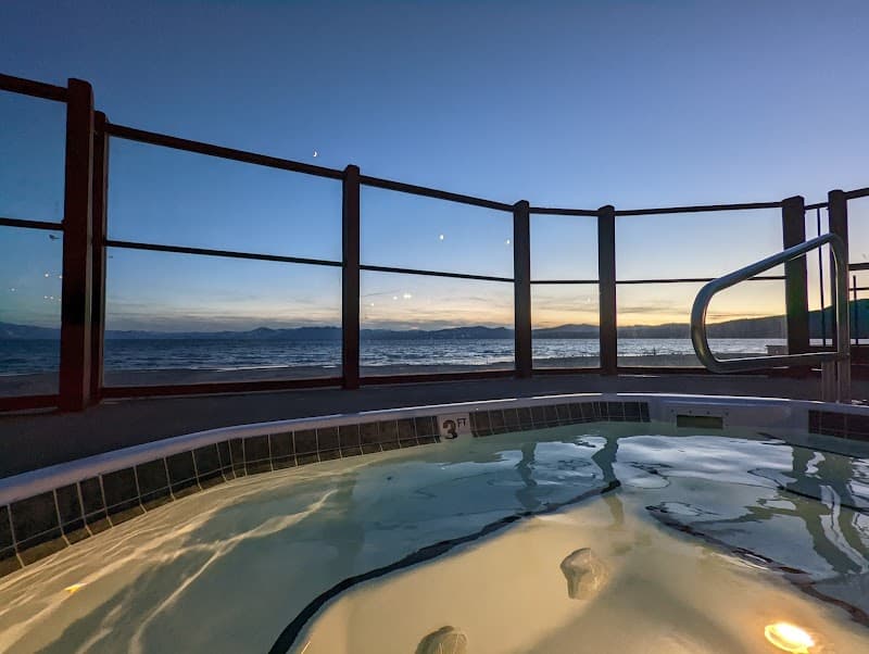 A serene evening at the Crown Motel in Kings Beach offers a tranquil hot tub experience with a breathtaking view of Lake Tahoe, ideal for travelers seeking relaxation and scenic beauty.